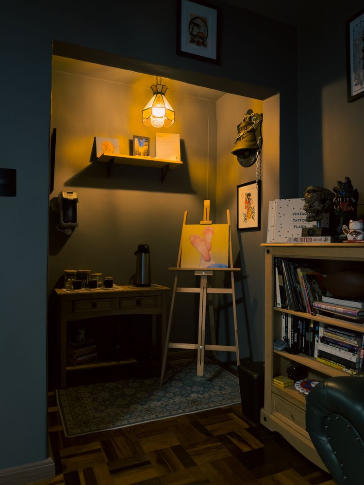 Canto do café com cavalete, luminária e estante de livros
