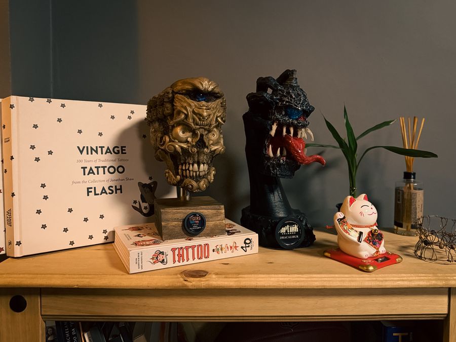 Prateleira com livros de flash tattoo e esculturas